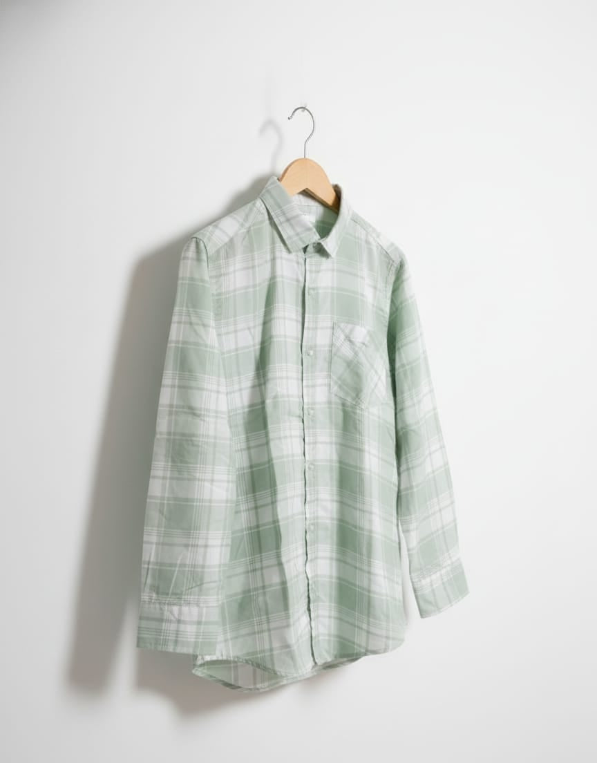 Green plaid shirt on a hanger against a white background
