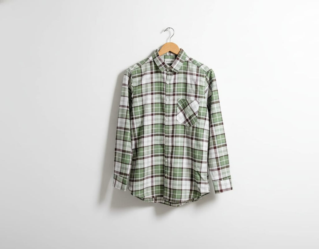Green and white plaid shirt on a hanger against a white background