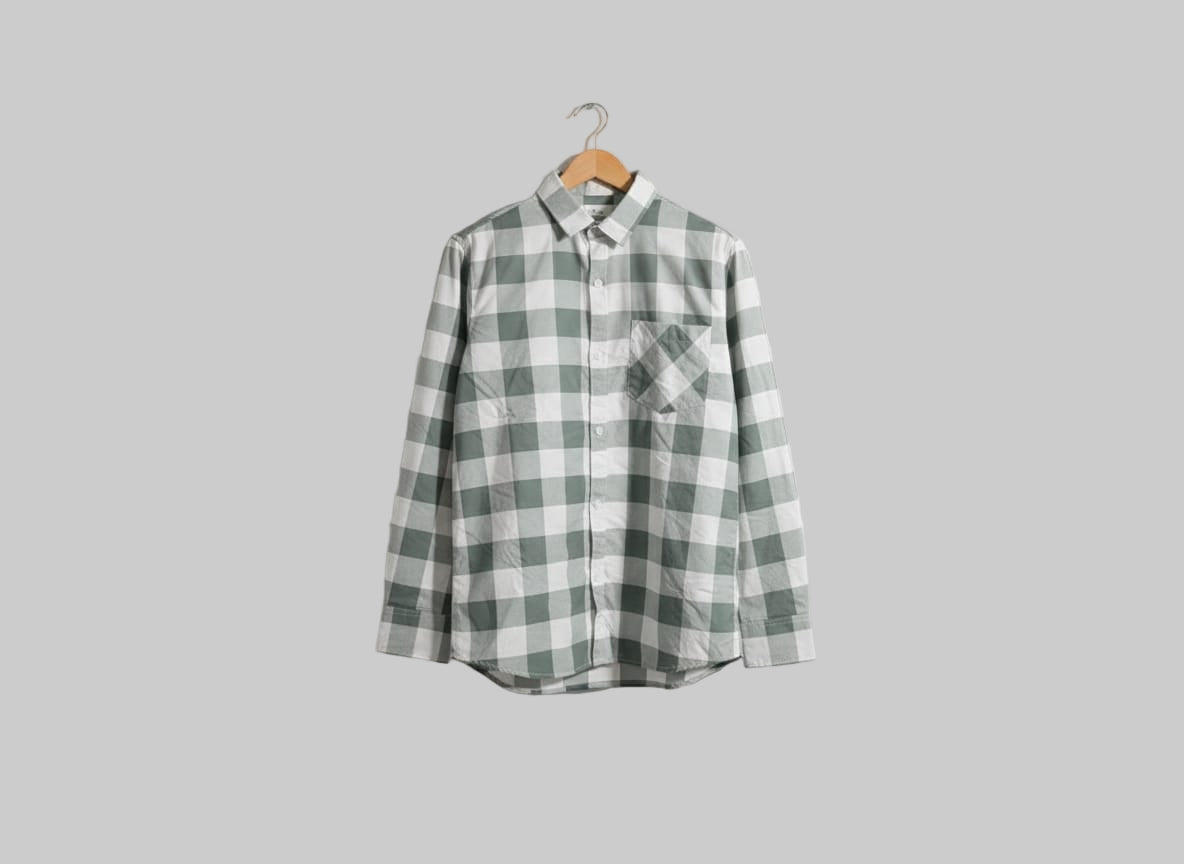 Green and white checkered shirt on a hanger against a white background