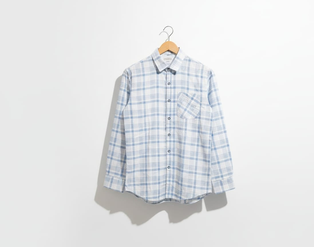 Plaid shirt on a hanger against a white background