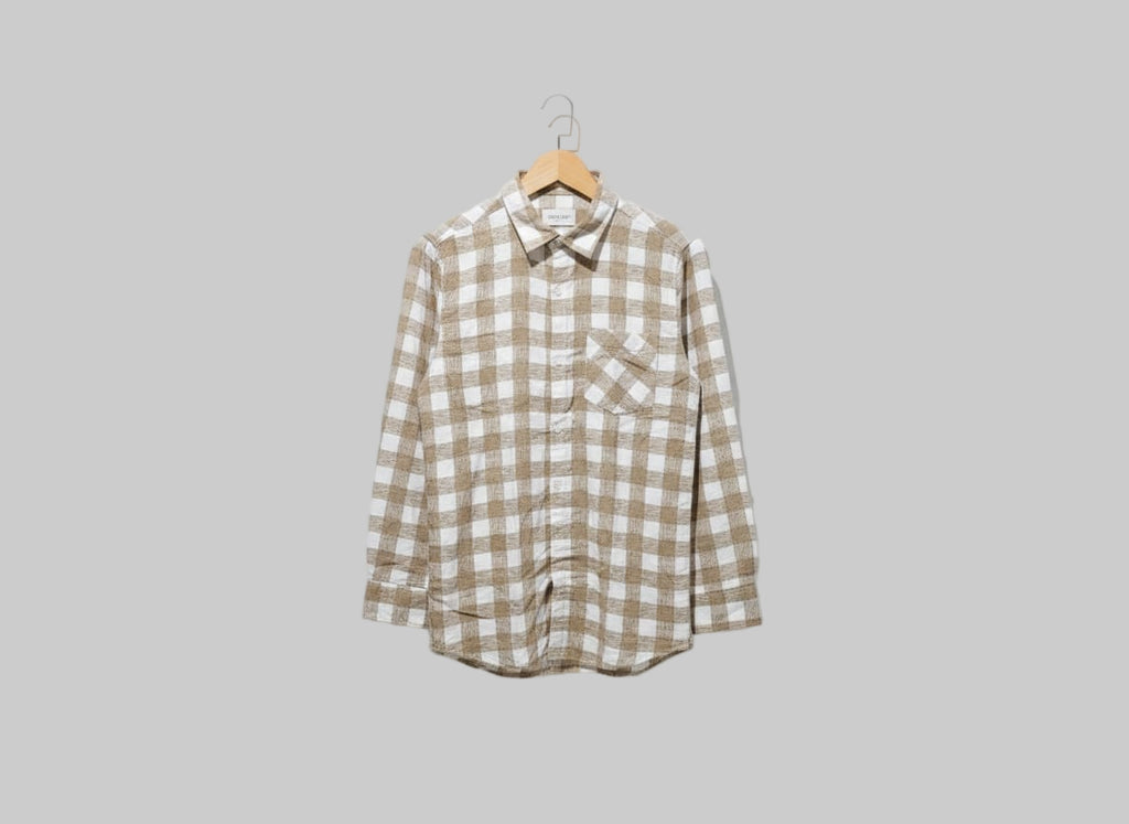 Plaid shirt on a hanger against a white background