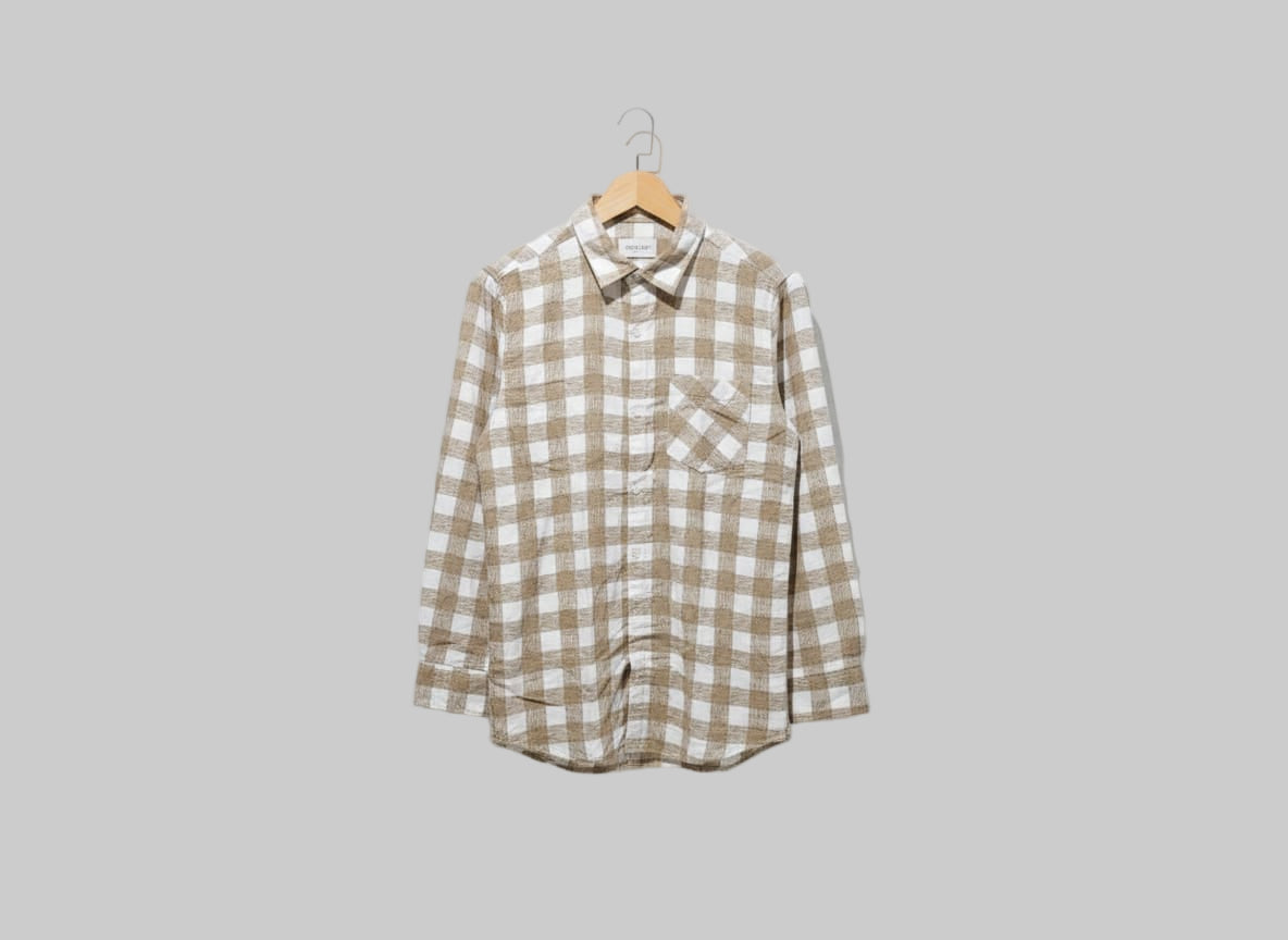 Plaid shirt on a hanger against a white background