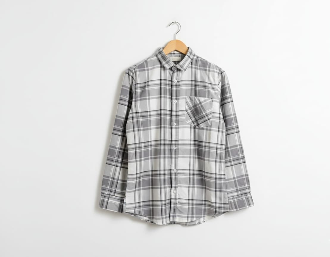 Plaid shirt on a hanger against a white background
